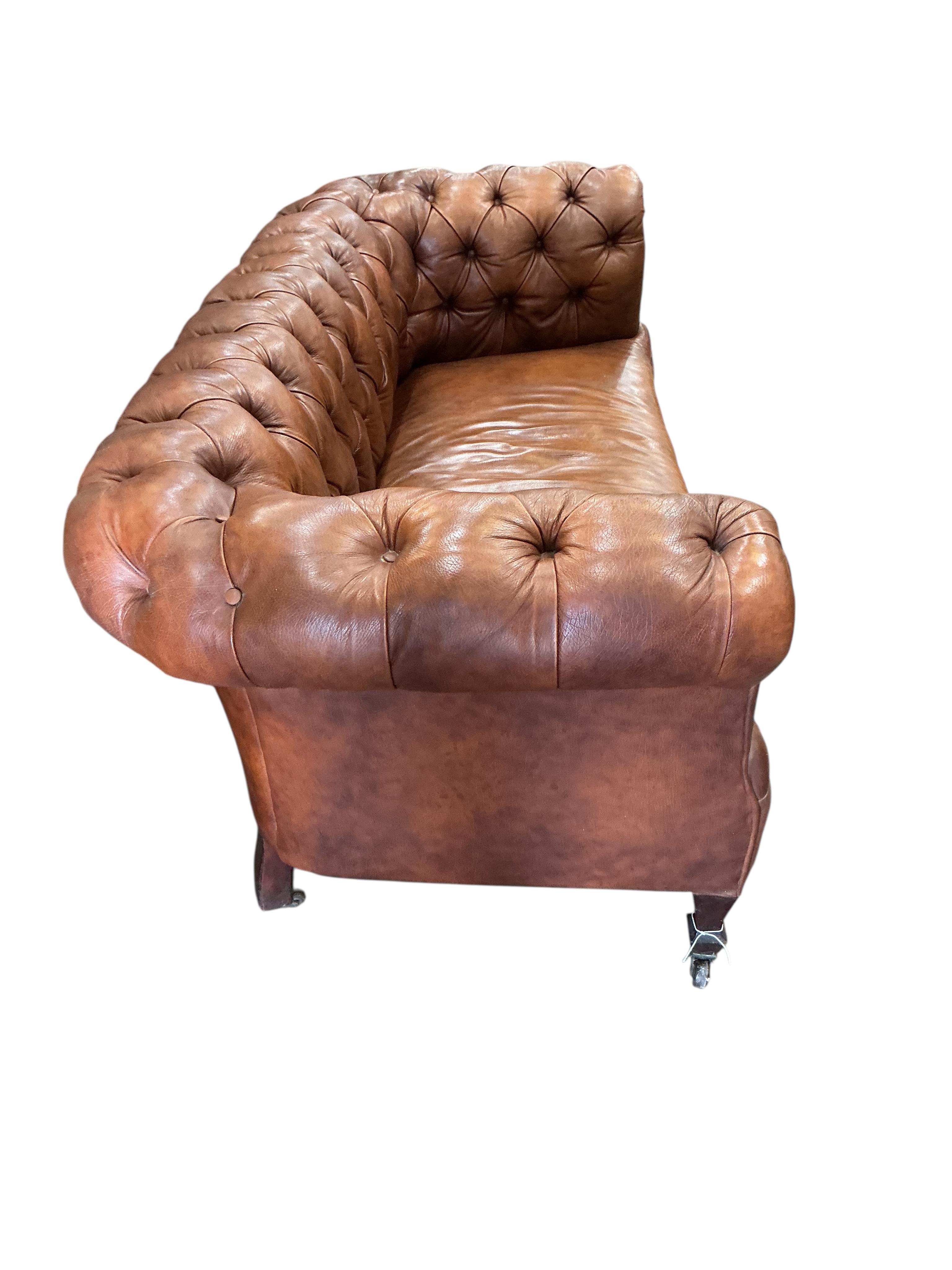 An early 20th century buttoned brown leather Chesterfield settee, width 180cm, depth 78cm, height 71cm